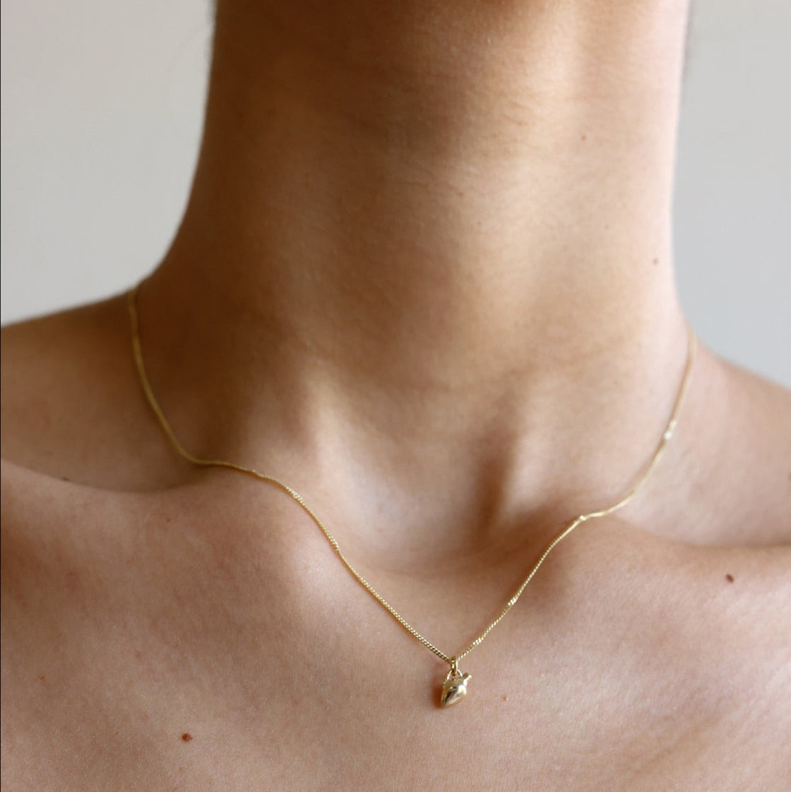 MINI VASE NECKLACE
English

A miniature vessel necklace handcrafted in 14K solid gold and suspended from a delicate curb chain. Small in scale yet rich in symbolism, it is a sculptural object that balances softness, femininity, and quiet presence.

Throughout history, the vessel has been a feminine, mystical, and ceremonial symbol. In biblical tradition, a vessel represents a person chosen to carry purpose and meaning. At its essence, the vessel symbolizes the human body—particularly the female body that ho