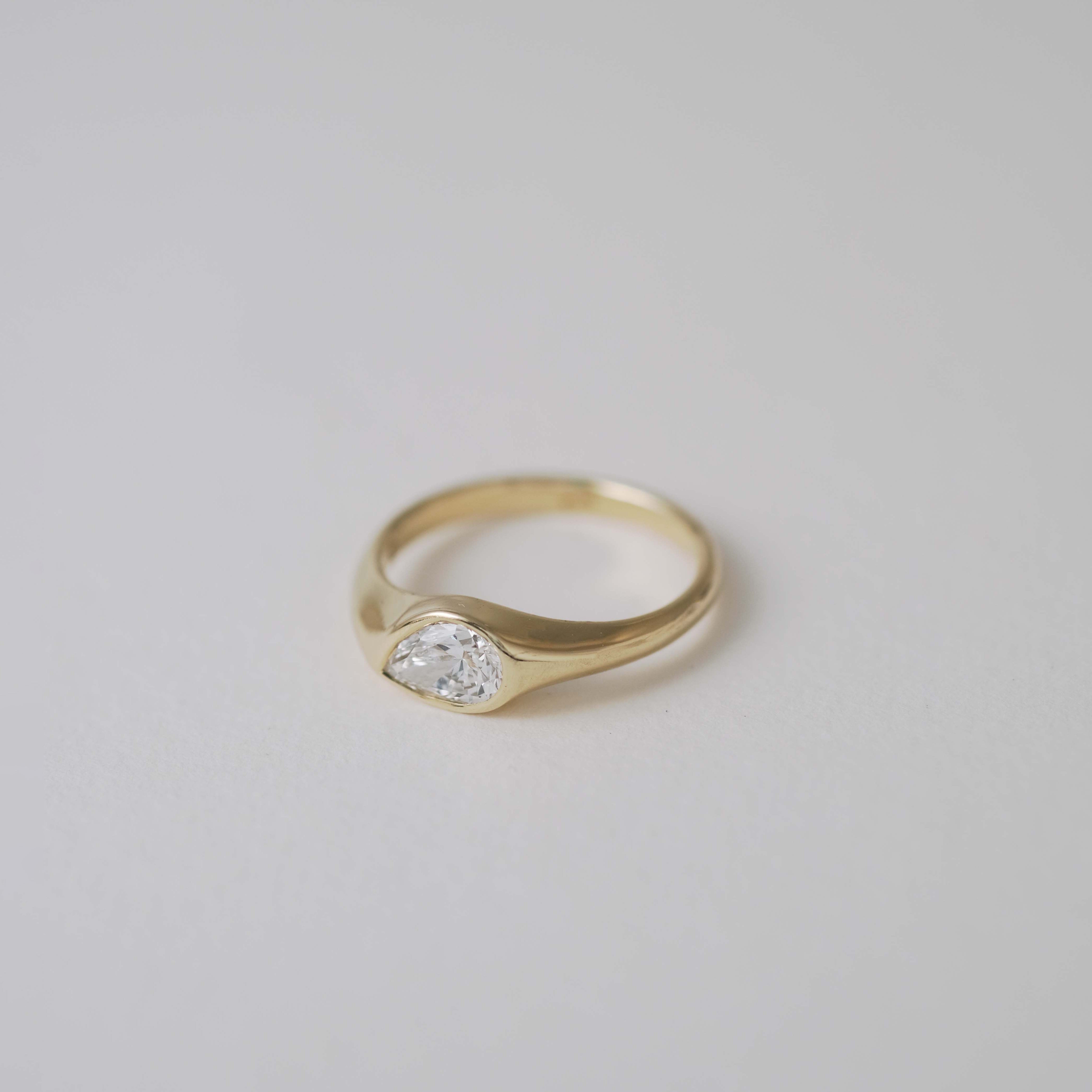 A teardrop-shaped diamond ring that captures natural movement through soft, fluid geometry. The pear-cut diamond blends marquise and oval influences, creating a silhouette that feels both delicate and powerful.
The DIAMOND DROP II is a 14K solid gold Fine Jewelry engagement ring, handcrafted in the Ruby Star studio. It represents contemporary luxury jewelry at its most refined—minimal, organic, and quietly expressive.
Designed as a modern heirloom, this piece balances comfort, elegance, and sculptural clari