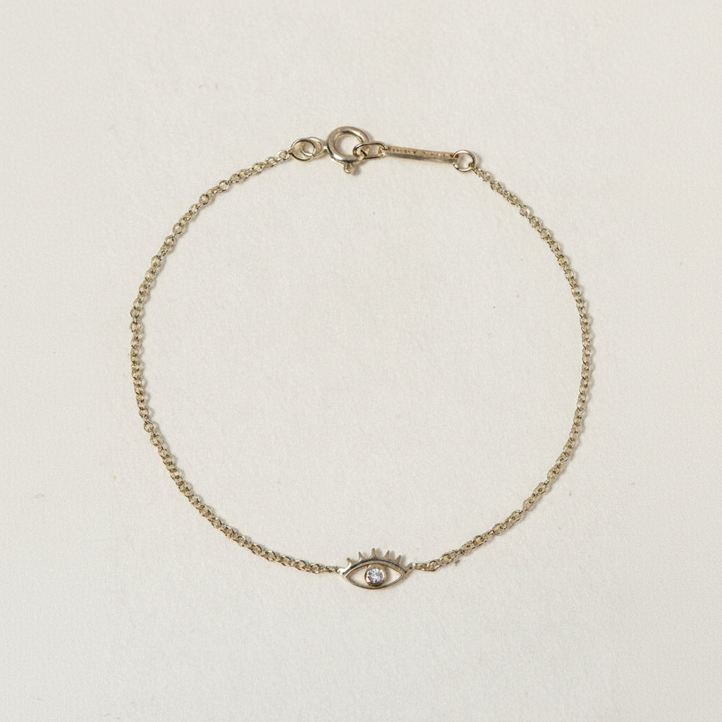 A miniature eye crafted in 14K solid gold. Delicate in scale yet rich in symbolism, it is a quiet object that bridges the visible and the unseen, balancing sculptural simplicity with meaningful design.

The symbolism of the eye has existed for thousands of years and is deeply associated with consciousness and awareness. The Evil Eye is worn for protection, the All-Seeing Eye represents divine providence, and the Third Eye symbolizes intuition, inner wisdom, and enlightenment.

The eye is a bridge between th