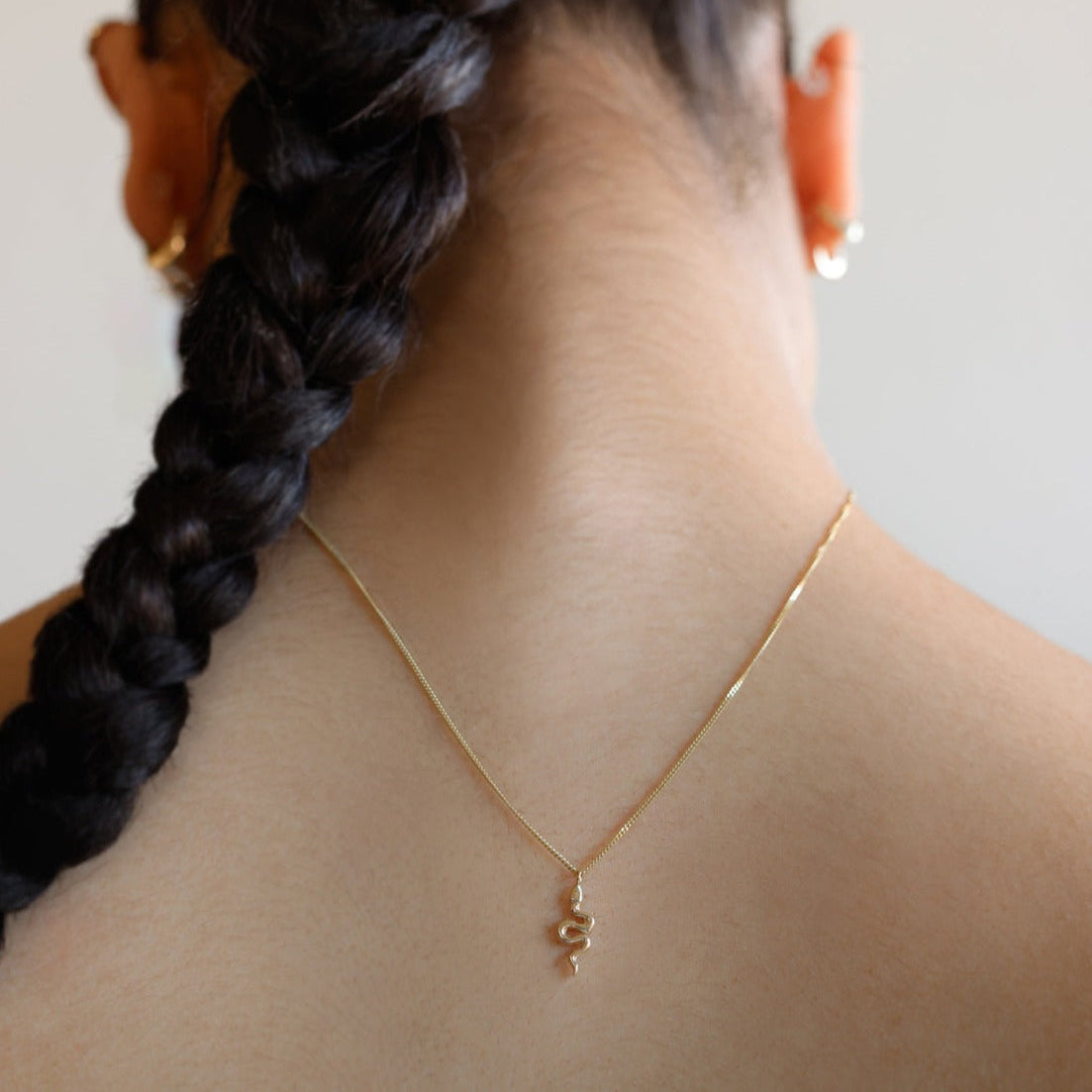 A miniature snake necklace handcrafted in 14K solid gold, suspended from a delicate curb chain. Small in scale yet rich in symbolism, it balances sculptural simplicity with quiet presence.

Throughout history, snakes have symbolized fertility, creative life force, and renewal. As snakes shed their skin to survive, they remind us of the importance of releasing what no longer serves us in order to grow and transform. They are enduring symbols of rebirth, healing, and personal evolution.

The MINI SNAKE NECKLA