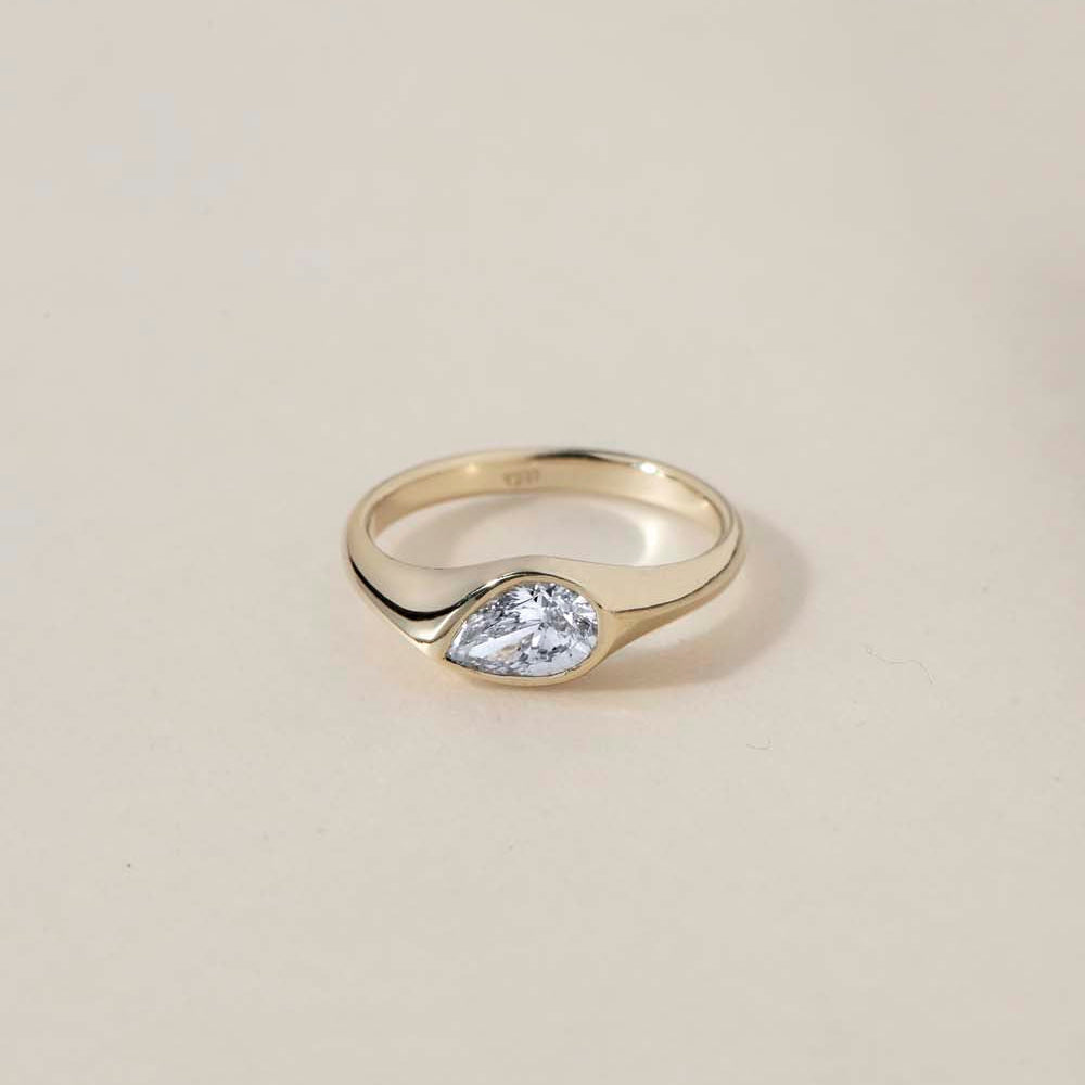 A teardrop-shaped diamond ring that captures natural movement through soft, fluid geometry. The pear-cut diamond blends marquise and oval influences, creating a silhouette that feels both delicate and powerful.
The DIAMOND DROP II is a 14K solid gold Fine Jewelry engagement ring, handcrafted in the Ruby Star studio. It represents contemporary luxury jewelry at its most refined—minimal, organic, and quietly expressive.
Designed as a modern heirloom, this piece balances comfort, elegance, and sculptural clari
