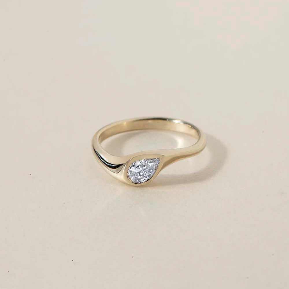 DIAMOND DROP I
A teardrop diamond ring with a softer architectural presence, where bezel setting and organic lines merge into a fluid silhouette.
The DIAMOND DROP I is a 14K solid gold Fine Jewelry engagement ring designed with quiet strength and modern elegance.
Handcrafted in the Ruby Star studio as a modern heirloom piece.
Details:
• 0.50ct pear-shaped diamond (natural or lab-grown F VS)
• Bezel setting
• 14K solid gold
• Handmade fine jewelry
• Organic sculptural design
A luxury pear-cut engagement ring