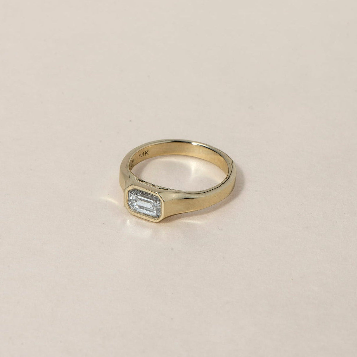 GRAND ARISE RING
An architectural Art Deco-inspired engagement ring defined by elevation, structure, and refined geometry. The emerald-cut diamond is lifted within a sculptural composition that enhances brilliance and presence.
The GRAND ARISE RING is a 14K solid gold Fine Jewelry piece that merges contemporary design with timeless luxury craftsmanship. Its bezel-structured form creates a seamless connection between gold and diamond.
Handcrafted in the Ruby Star studio, it is designed as a modern heirloom e