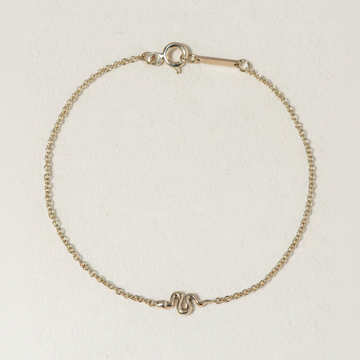 A miniature snake bracelet handcrafted in 14K solid gold. Delicate yet symbolic, it is a quiet expression of transformation, balancing sculptural simplicity with meaningful design.

Throughout history, snakes have represented fertility, creative life force, and renewal. As snakes shed their skin to survive, they remind us of our own ability to release, evolve, and begin again. They are enduring symbols of healing, rebirth, and personal transformation.

The MINI SNAKE BRACELET is a handcrafted Fine Jewelry p