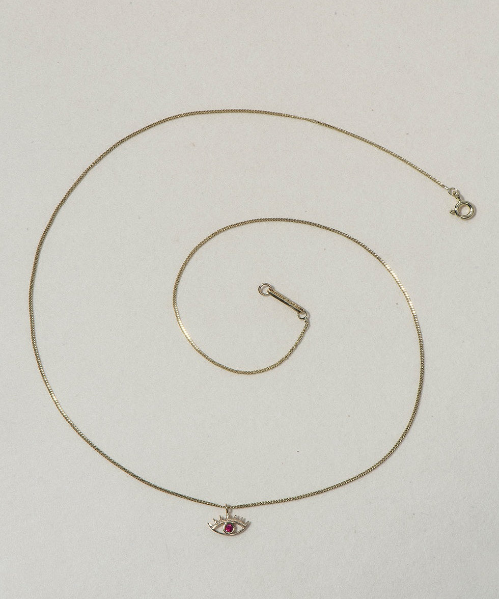 MINI EYE NECKLACE
English

A miniature eye necklace handcrafted in 14K solid gold and suspended from a delicate curb chain. Small in scale yet rich in meaning, it is a quiet symbolic object that balances sculptural simplicity with a sense of protection and inner awareness.

The symbolism of the eye has existed for thousands of years and has always been associated with consciousness and perception. The Evil Eye is worn for protection, the All-Seeing Eye represents divine providence, and the Third Eye symboli