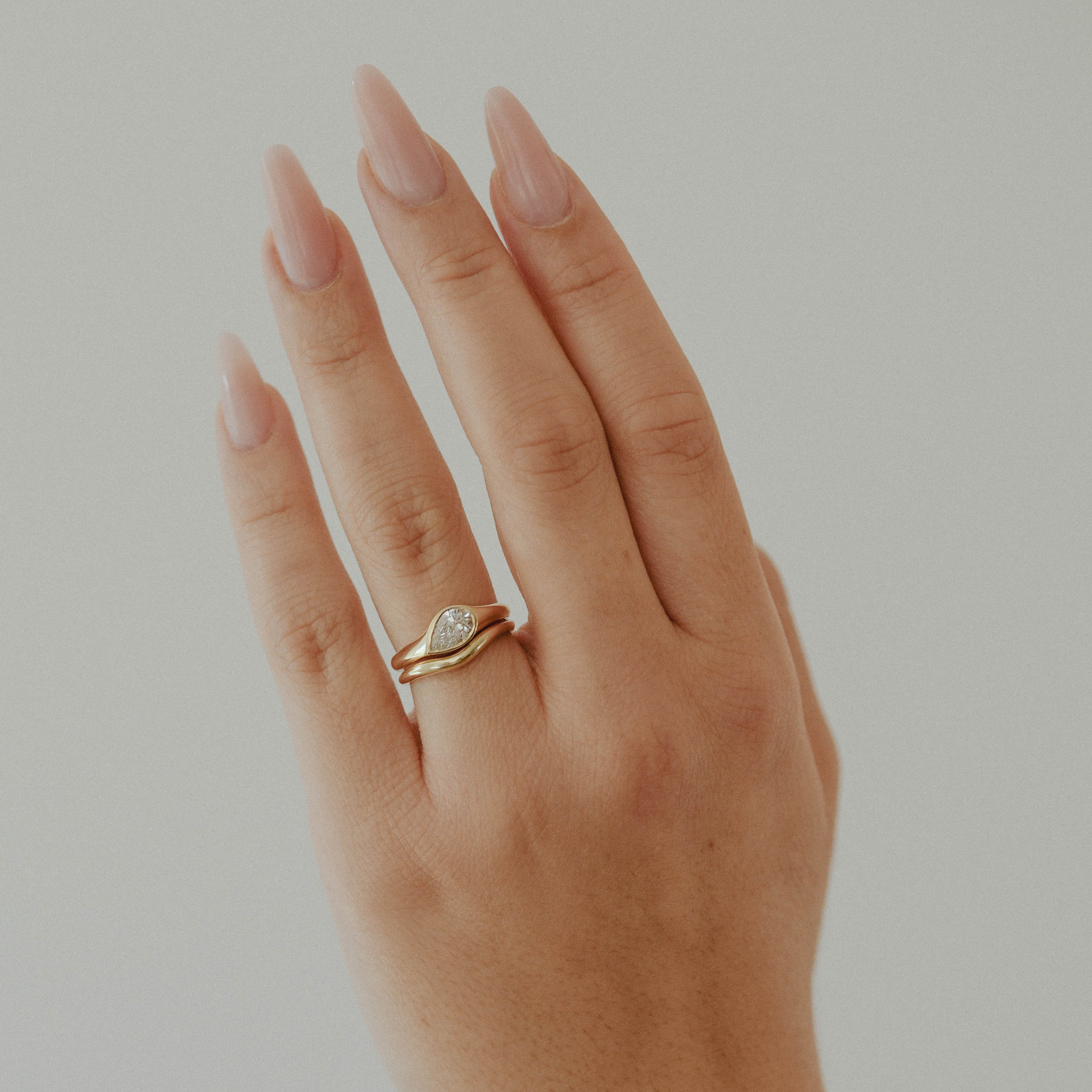 A teardrop-shaped diamond ring that captures natural movement through soft, fluid geometry. The pear-cut diamond blends marquise and oval influences, creating a silhouette that feels both delicate and powerful.
The DIAMOND DROP II is a 14K solid gold Fine Jewelry engagement ring, handcrafted in the Ruby Star studio. It represents contemporary luxury jewelry at its most refined—minimal, organic, and quietly expressive.
Designed as a modern heirloom, this piece balances comfort, elegance, and sculptural clari