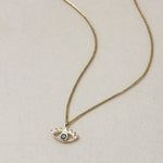 MINI EYE NECKLACE
English

A miniature eye necklace handcrafted in 14K solid gold and suspended from a delicate curb chain. Small in scale yet rich in meaning, it is a quiet symbolic object that balances sculptural simplicity with a sense of protection and inner awareness.

The symbolism of the eye has existed for thousands of years and has always been associated with consciousness and perception. The Evil Eye is worn for protection, the All-Seeing Eye represents divine providence, and the Third Eye symboli