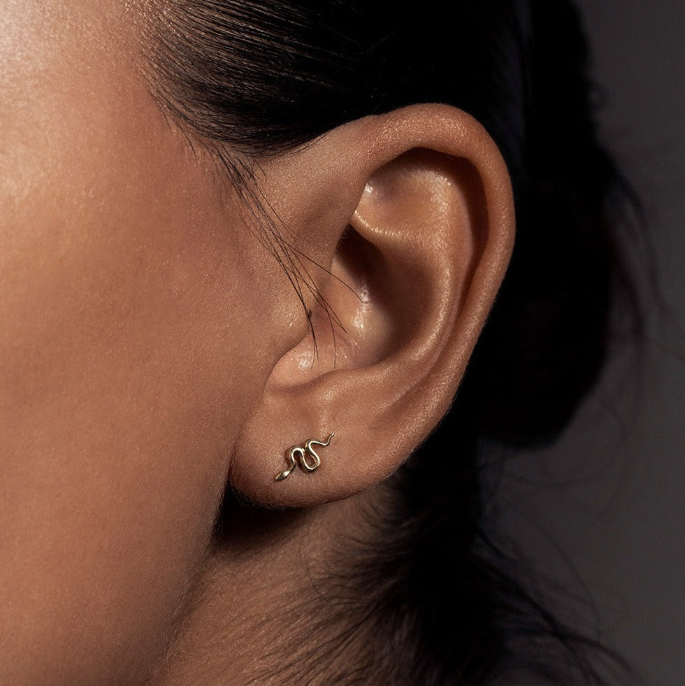 MINI SNAKE STUD

A miniature snake crafted in 14K solid gold. A small symbolic object with a quiet presence, balancing sculptural simplicity with profound meaning.

Historically, snakes have represented fertility, creative life force, and renewal. As snakes shed their skin in order to survive, they remind us of the importance of releasing what no longer serves us so that we may grow and transform.

The MINI SNAKE STUD is a handcrafted Fine Jewelry piece, created in the Ruby Star studio by local artisans. It