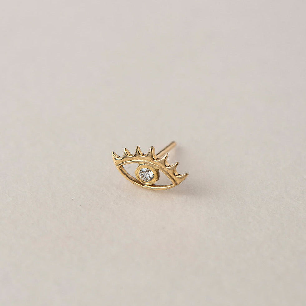 A miniature eye crafted in 14K solid gold. Delicate in scale yet rich in symbolism, it is a quiet object that bridges the visible and the unseen, balancing sculptural simplicity with meaningful design.

The symbolism of the eye has existed for thousands of years and is deeply associated with consciousness and awareness. The Evil Eye is worn for protection, the All-Seeing Eye represents divine providence, and the Third Eye symbolizes intuition, inner wisdom, and enlightenment.

The eye is a bridge between th