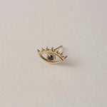 A miniature eye crafted in 14K solid gold. Delicate in scale yet rich in symbolism, it is a quiet object that bridges the visible and the unseen, balancing sculptural simplicity with meaningful design.

The symbolism of the eye has existed for thousands of years and is deeply associated with consciousness and awareness. The Evil Eye is worn for protection, the All-Seeing Eye represents divine providence, and the Third Eye symbolizes intuition, inner wisdom, and enlightenment.

The eye is a bridge between th