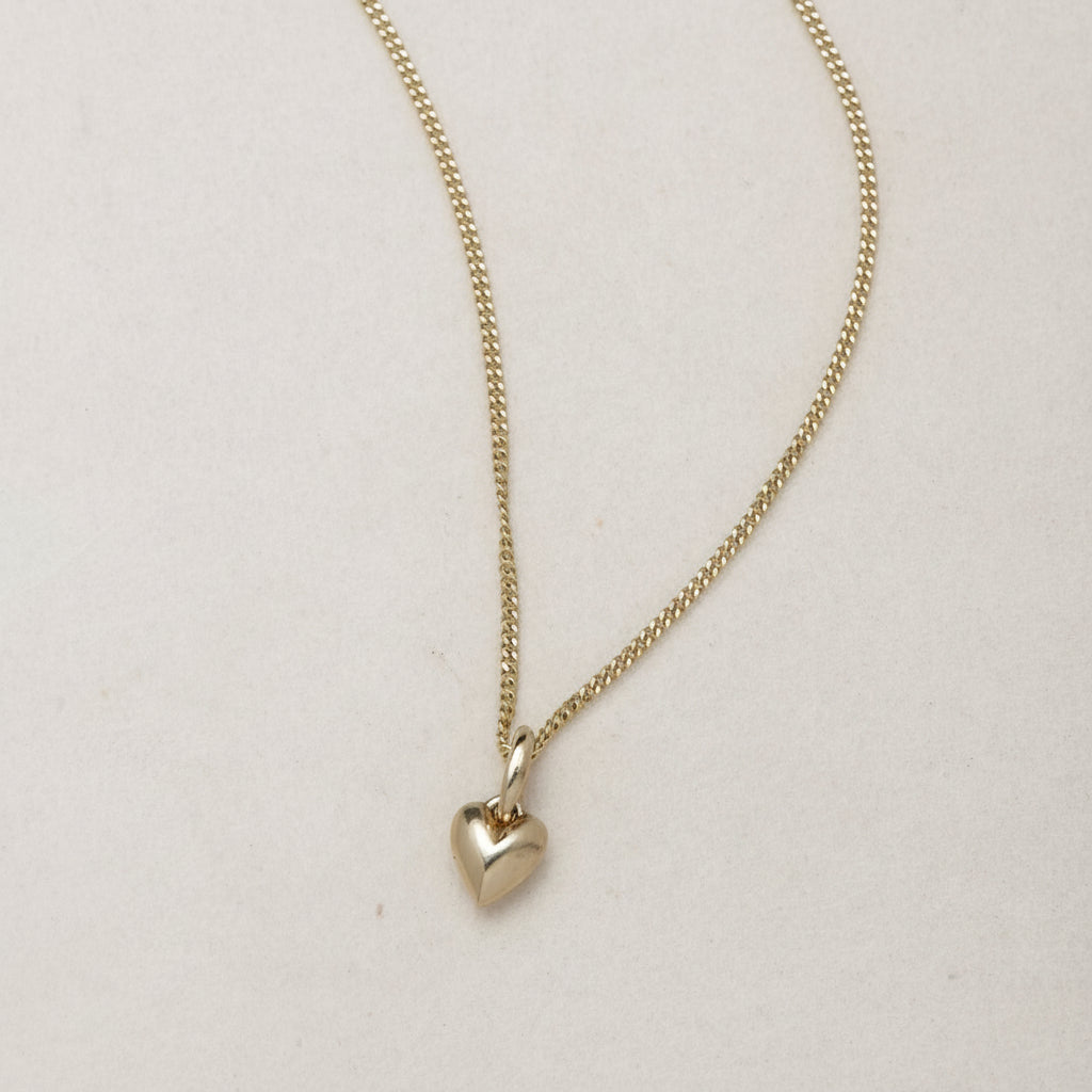 Mini Heart Necklace | 14K Gold Symbol of Love | Ruby Star Studio

META DESCRIPTION

A miniature heart necklace handcrafted in 14K gold. A timeless symbol of love, connection, compassion and emotional strength. Fine jewelry by Ruby Star Studio.

MINI HEART NECKLACE

A timeless symbol of love, carried close to the heart.

The Mini Heart Necklace is handcrafted in solid 14K gold and designed as a modern heirloom for everyday wear. Delicate in scale yet rich in meaning, this miniature heart pendant celebrates t
