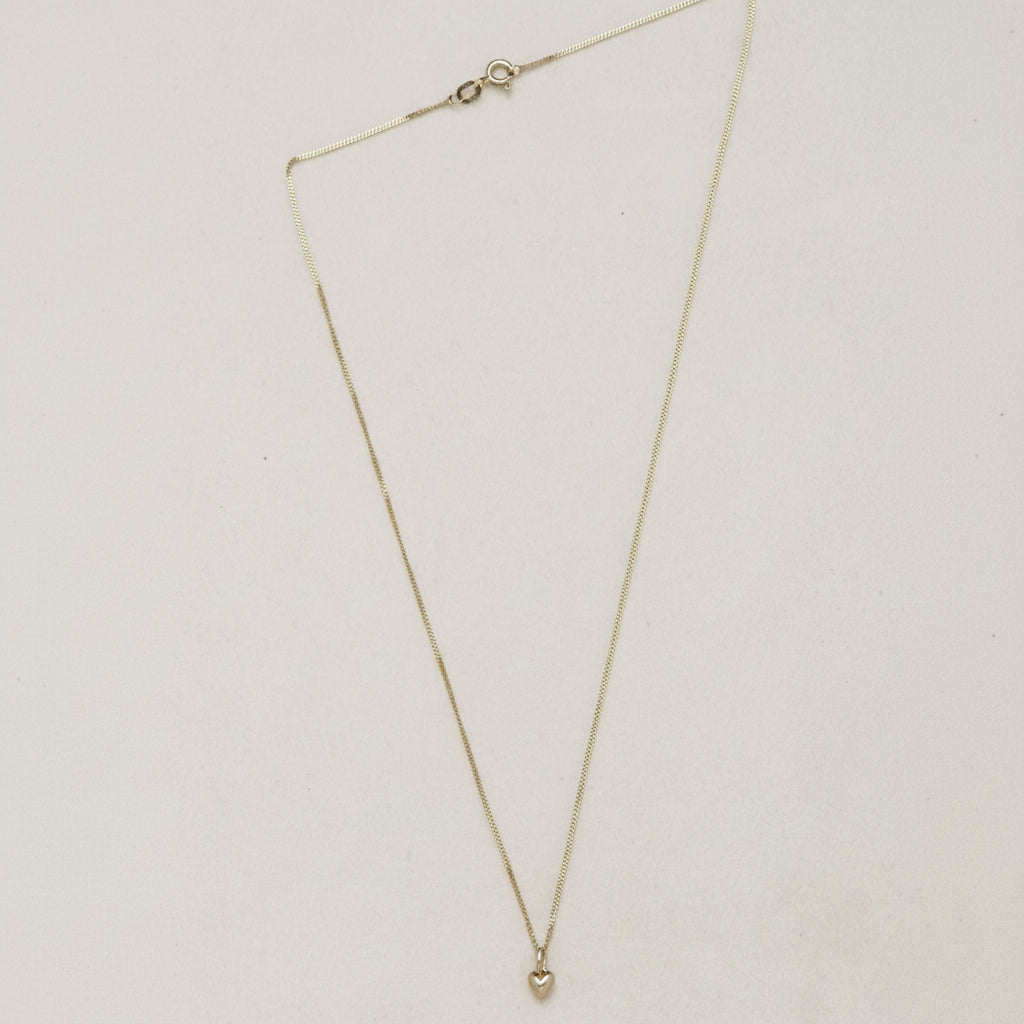 Mini Heart Necklace | 14K Gold Symbol of Love | Ruby Star Studio

META DESCRIPTION

A miniature heart necklace handcrafted in 14K gold. A timeless symbol of love, connection, compassion and emotional strength. Fine jewelry by Ruby Star Studio.

MINI HEART NECKLACE

A timeless symbol of love, carried close to the heart.

The Mini Heart Necklace is handcrafted in solid 14K gold and designed as a modern heirloom for everyday wear. Delicate in scale yet rich in meaning, this miniature heart pendant celebrates t